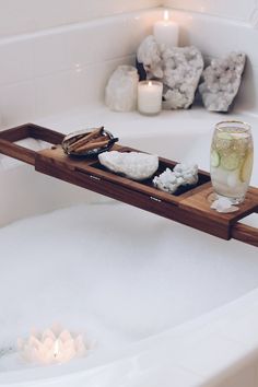 a bathtub with candles and soaps in it