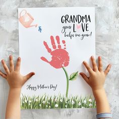 two children holding up a handprinted card with the words grandma you've helped us grow