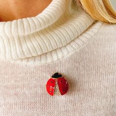 This cute ladybird pin is crafted with enamel and sparkly crystals, offset against gold plating. Ladybird jewelry is a classic motif, and will put a smile on any vintage loving wearer. Try wearing your ladybird brooch with knitwear, for a sparkling touch or with a 1970s broderie anglaise dress for a dreamy style. A vintage inspired piece, this sweet motif is perfect for vintage loving nature fans! Called ladybirds in the UK or ladybugs on the other side of the Atlantic, they represent prosperity, love and luck everywhere! Each ladybird brooch arrives lovingly gift wrapped in tissue, organza gift pouch, and with a gift box, so it's gift ready. Treat yourself or a friend! Measures approximately  2.7 cm wide by 2.6 cm long Red Enamel Pins For Gifts, Red Enamel Brooch, Red Enamel Brooch Pin, Red Enamel Pin As Gift, Red Enamel Pin Gift, Red Enamel Pin For Gift, Red Enamel Brooches As Gift, Red Enamel Brooch Jewelry, Red Enamel Brooches For Gift