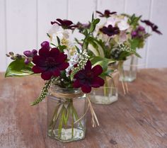 three mason jars filled with purple and white flowers