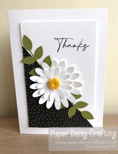 a card with a white flower on it and the words thanks written in black ink