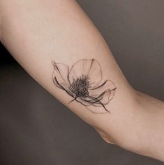 a woman's arm with a flower tattoo on it