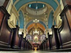 the inside of a church with pews and chandeliers