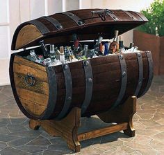 an old wooden trunk filled with lots of bottles and liquors sitting on top of a stone floor