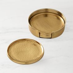 two gold trays sitting on top of a white countertop next to each other