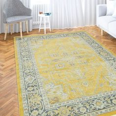 a living room with a large yellow rug on the floor