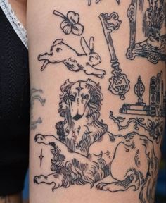 a woman's arm with tattoos on it, including dogs and other things in black ink