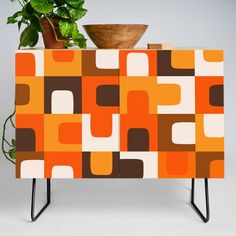 a potted plant sitting on top of an orange and brown cabinet