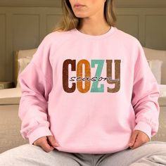 "Stay Cozy Sweatshirt,Winter Shirt,Let's Get Cozy T shirt,Cozy Cuddles Tshirt,Fall Quotes T-shirt,Cozy Season Apparel,Cold Weather Tee, Thank you so much for taking the time to browse my shop. Please feel free to reach out if you have any questions before or after purchasing.  💖 🎨Warning: On products with a print chart in the listing, metallic print colors are printed as matte. We design and cut each graphic out with a soft touch, use matte vinyl and a heat press. The result will last for many washes. PRODUCT DESCRIPTION: Our sweatshirt are super comfortable and the quality is excellent, they are manufactured with cotton fibers to ensure comfort and durability. Polyester fibers are extremely strong, and resistant to most chemicals, along with shrinkage. 50% cotton, 50% polyester. The siz Cute Winter Sweatshirt With Letter Print, Cozy Fit Hoodie With Letter Print, Comfortable Pink Winter Tops, Comfy Letter Print Hoodie Sweatshirt, Comfy Hoodie Sweatshirt With Letter Print, Winter Graphic Print Comfortable Sweatshirt, Winter Graphic Print Sweatshirt, Comfortable Graphic Print Winter Sweatshirt, Cozy Letter Print Hoodie Sweatshirt