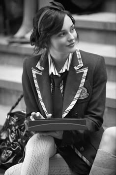 a woman is sitting on the steps with her purse and looking at something in her hand