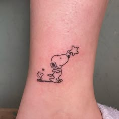 a small tattoo on the ankle of a person with a dog and star in it