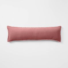 a pink pillow on a white wall