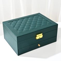 a green box with a gold handle on a white surface