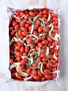 a tray filled with tomatoes and onions on top of a table