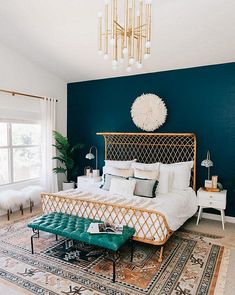 a bedroom with blue walls and white bedding, gold headboard and foot board