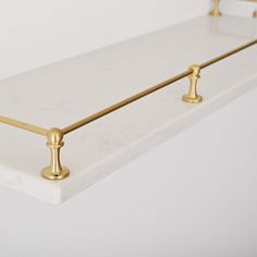 a white shelf with gold handles and knobs