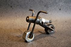 a pair of wrenches sitting on top of a table next to some screws