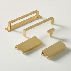 four pieces of brass furniture on a white surface