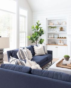 a living room with blue couches and white walls