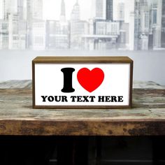 a sign that says i love your text here on top of a table in front of a cityscape