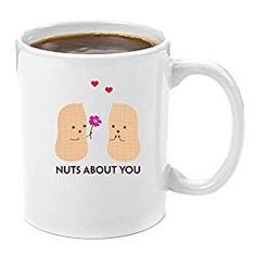 a white coffee mug with two toasted breads and the words nuts about you on it