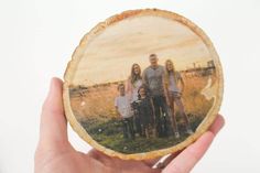 a hand holding up a wood slice with the words mod podge printed on it