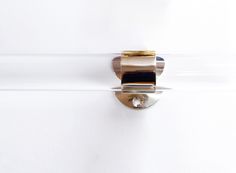 a close up of a glass door handle on a white wall with gold trimming