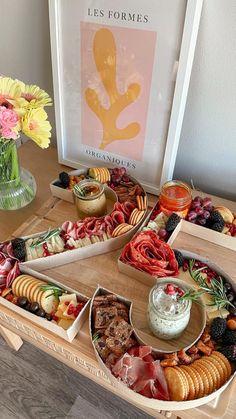 an assortment of appetizers are arranged on a tray with flowers in a vase