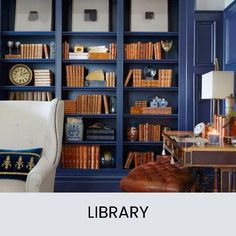 a library with blue bookshelves and leather chairs in front of the bookcase