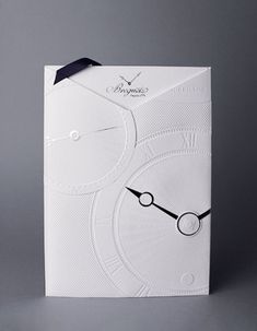 a white box with a black clock on the front and back side, sitting on a gray surface