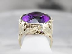 This amethyst cocktail ring is jaw-dropping! The amethyst is full of sparkle, radiating colors of lavender and violet. The mounting is extraordinary, with leaf accents that stretch beautifully around the ring, making the amethyst look like it is nestled in a garden! Metal: 14K Green Gold Gem: Amethyst 30.00 Carats Gem Measurements: 19.1 x 27.3 mm, Oval Ring Size: 10.75 Marks: "14K" Stamped on the inside band Unique Purple Amethyst Ring For Wedding, Unique Purple Amethyst Wedding Ring, Unique Purple Amethyst Ring For Anniversary, Amethyst Cocktail Ring, Floral Cocktails, Estate Ring, Right Hand Ring, Demantoid Garnet, Ring Making