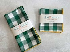 two green and white plaid napkins sitting on top of each other next to one another