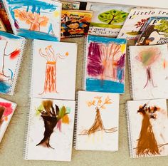 many children's drawings are displayed on the table