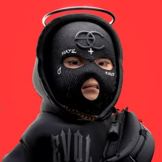 a man wearing a black mask and hood with writing on his face, in front of a red background