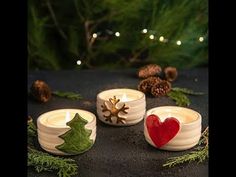 three candles with christmas decorations and pine cones