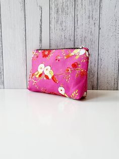 "Cute little zippered pouch. Perfect for loose change, credit card and small set of keys. Or holding small items in your bag that would normally roll around the bottom.  The outer fabric is cute birds on a bright pink background. The lining is pale blue. Made from 100% cotton. Closes with a gold coloured zip with a feather zip pull. Height: 12.7cm (5\") Width: 15.2cm (6\") Depth: 4.5cm (1.75\")" Pink Coin Purse With Removable Pouch, Pink Pouch Coin Purse With Zipper, Pink Zipper Pouch Cosmetic Bag, Pink Zipper Pouch Coin Purse, Rectangular Pink Coin Purse For Personal Use, Bright Pink Background, Small Zipper Pouch, Loose Change, Zippered Pouch