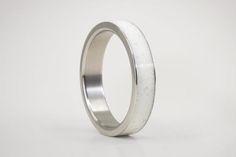 We present our white Carrara marble ring with polished titanium edges outside.This beautiful marbled band has titanium on the inside.Since we develop this material, every ring will have a unique grain and be one of a kind. -- MATERIALS --We use reconstituted Carrara marble developed in our workshop. We carefully select marble grains, known as one of the most prized marbles for its fine grain whiteness and floury appearance. We combine it with titanium, a material that we use both on its own or c White Stainless Steel Jewelry With Polished Finish, White Polished Stainless Steel Jewelry, Mens Wedding Rings Titanium, White Wedding Ring, Marble Ring, Stone Wedding Ring, Marble Rings, Stone Wedding, Organic Jewelry