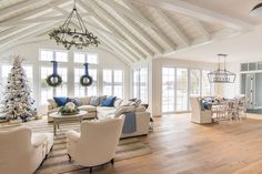 a living room filled with furniture and a christmas tree in the middle of the room