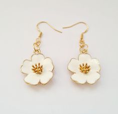 White Flower Earrings A gold and white coloured charm on a gold coloured hook. All my earrings are lead and nickel free and are silver plated. Handmade with love and care. Sold in pairs. Colours may vary slightly from photos on your laptop/phone/tablet.  International postage will be sent tracked and/or signed for depending on your location, hence the higher delivery costs. White Dangle Flower Earrings For Birth Month, White Dangle Earrings With Birth Flower, White Birth Flower Earrings, White Dangle Birth Flower Earrings, White Birth Flower Dangle Earrings, White Birth Flower Drop Earrings, White 14k Gold Flower-shaped Earrings, Chic White Flower-shaped Earrings, Nickel-free Yellow Flower Earrings