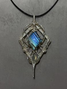 Unveil the magic of labradorite with this exquisite handcrafted pendant necklace.  Key Features: - Stunning labradorite gemstone with mesmerizing blue flash - Intricately wire-wrapped in sterling silver - Art Nouveau-inspired design - Necklace length: Adjustable black cord This one-of-a-kind pendant showcases a carefully selected labradorite stone, renowned for its ethereal blue flash and mystical properties. The stone is unique, ensuring your piece is truly one-of-a-kind. The gemstone is loving Ethereal Blue, Jewelry Care Instructions, Handcrafted Accessories, Art Nouveau Style, Elegant Art, Necklace Unique, Hand Shapes, Silver Art, Labradorite Pendant