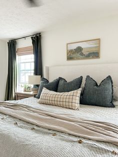 a large bed sitting in a bedroom next to a window