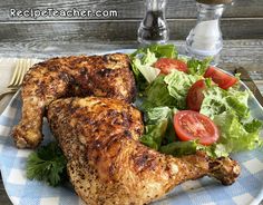 a white and blue plate topped with chicken, lettuce and tomato wedges