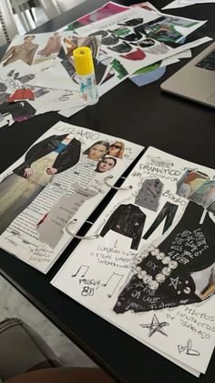 the table is covered with papers and pictures, including clothes on top of each other