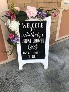 a sign with flowers on it that says welcome to mathusy's bridal shower