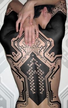 a woman with her back covered in black and white designs, holding her hand on top of her body