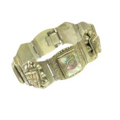 1960s Mexico Taxco alpaca silver bracelet. Hinged curved platforms. some engraved around bezel-set squares of polished abalone, alternating with carved abalone Mayan deity heads embellished w/ twisted rope headdresses and silver half-globes. Intricate hand workmanship and gleaming iridescent abalone make this a singular and striking artifact. Exceptional condition, and much more vibrant in person. Signed "Made Taxco Alpaca". Vintage Abalone Shell Jewelry Gift, Carved Silver Rectangular Jewelry, Carved Rectangular Silver Jewelry, Silver Carved Rectangular Jewelry, Vintage Abalone Shell Jewelry As A Gift, Vintage Abalone Shell Jewelry For Gift, Silver Rectangular Carved Jewelry, Handmade Vintage Abalone Shell Jewelry, Antique Rectangular Carved Jewelry