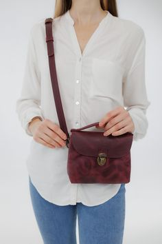 Crafted with meticulous attention to detail, these crossbody bags are the perfect blend of practicality and sophistication. Available in nine stunning colors, including classic neutrals and vibrant hues, there's a perfect match for every outfit and occasion. Elevate your ensemble with our Leather Purse for Women, the ultimate minimalist crossbody bag that makes a thoughtful and stylish gift for any occasion. This bag combines functionality with a sleek, modern aesthetic, making it a versatile accessory for various occasions. The interior of the backpack includes a pocket, which adds functionality by offering extra storage space. It's great for organizing your belongings and keeping smaller items secure and easily accessible. The bag has a top handle for easy carrying in your hand. The belt Everyday Hand-tooled Crossbody Bag, Mini Handbags Leather, Elegant Crossbody Camera Bag With Gold-tone Hardware, Leather Crossbody Camera Bag With Gold-tone Hardware, Leather Crossbody Shoulder Bag With Anti-theft Pocket, Purse For Women, Red Crossbody Bag With Gold-tone Hardware, Wet Clothes, Mini Handbag