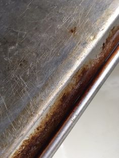 the rust on the side of a metal table is brown and has been stained off