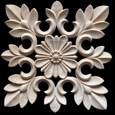 an intricately carved wall decoration with leaves and flowers in white on a black background