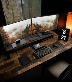 two computer monitors sitting on top of a wooden desk